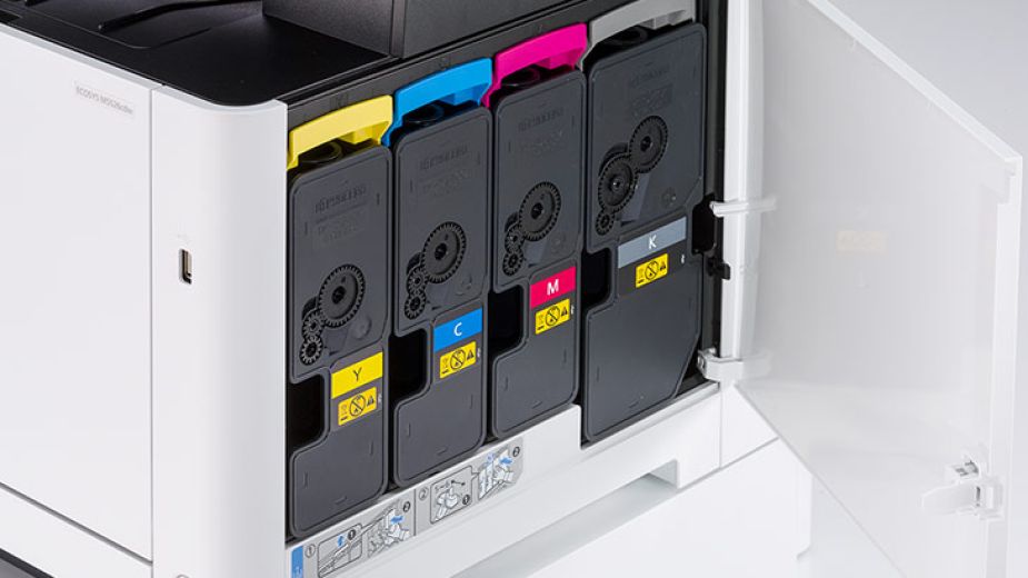 A close-up view of the toner cartridges inside a Kyocera printer. The four cartridges are labeled with their colors: yellow, cyan, magenta, and black.