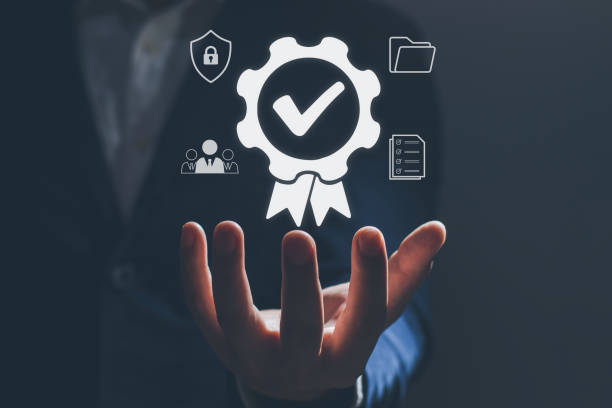 A hand is held palm-up, with a large, glowing certification badge floating above it. The badge is a gear with a checkmark inside, and it is surrounded by smaller icons representing security, teamwork, and data.