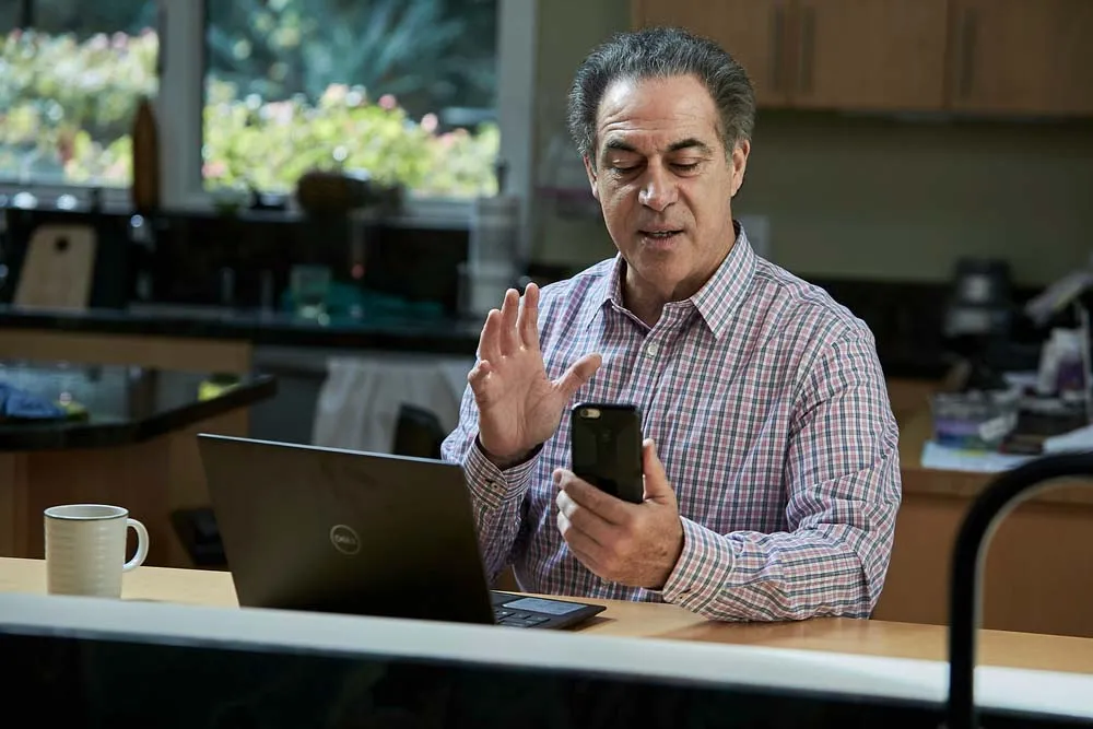 Financial professional using the Elevate UC mobile app for a video call, showcasing flexible business VoIP and remote calling solutions.