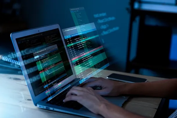 Person coding on a laptop with a digital code overlay, symbolizing cybersecurity and software development, highlighting cloud hosting, business email, and cloud email by Elevation Technology.