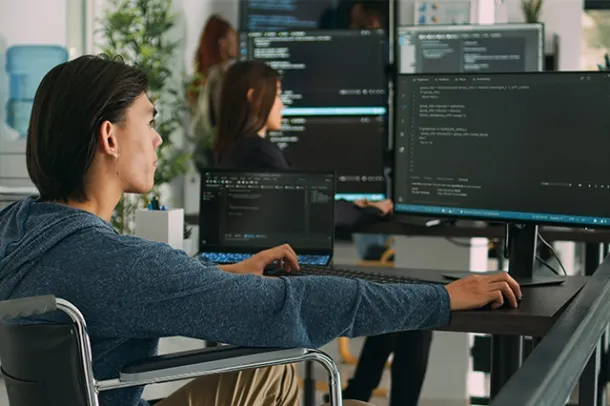 Team of IT professionals coding and monitoring software systems on multiple screens, representing managed services, cloud hosting, business email, and cloud email by Elevation Technology.