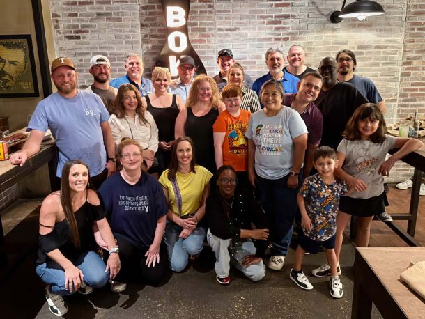Large group and families smiling at a bowling event, representing the community behind Elevate Technology, a mobile technology solution provider.