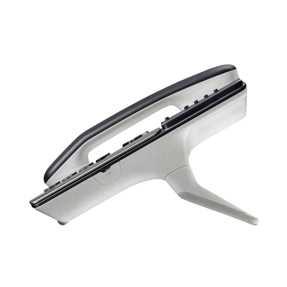 Doctor using a desk phone while working on a laptop in a clinic, demonstrating how Elevate UC for Healthcare empowers patient-centered communication.