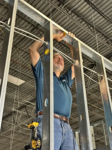 Mobile-friendly visual of a professional installing low-voltage wiring, representing expert IT infrastructure, cloud hosting, business email, and cloud email by Elevation Technology.