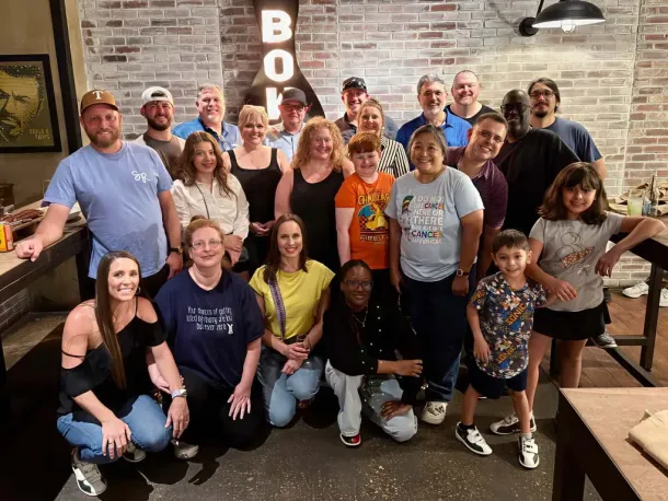 Large group and families smiling at a bowling event, representing the community behind Elevate Technology, a mobile technology solution provider.