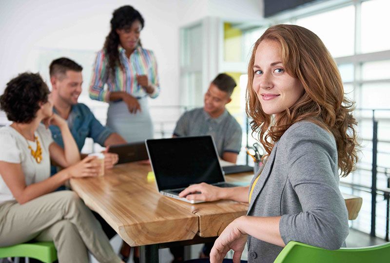 A professional stock photo for Elevate Technology, showing a diverse team of five people meeting in a modern, light-filled office.