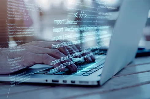 A developer's hands typing on a laptop with an overlay of code, highlighting software development, programming, and coding.