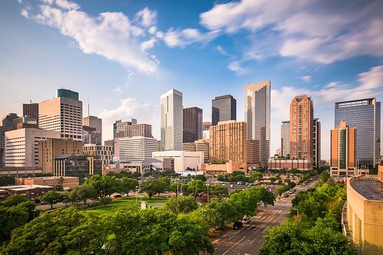 Skyline of downtown Houston, Texas with modern skyscrapers and greenery, representing Elevate Technology’s local IT support and managed services for businesses in Houston.